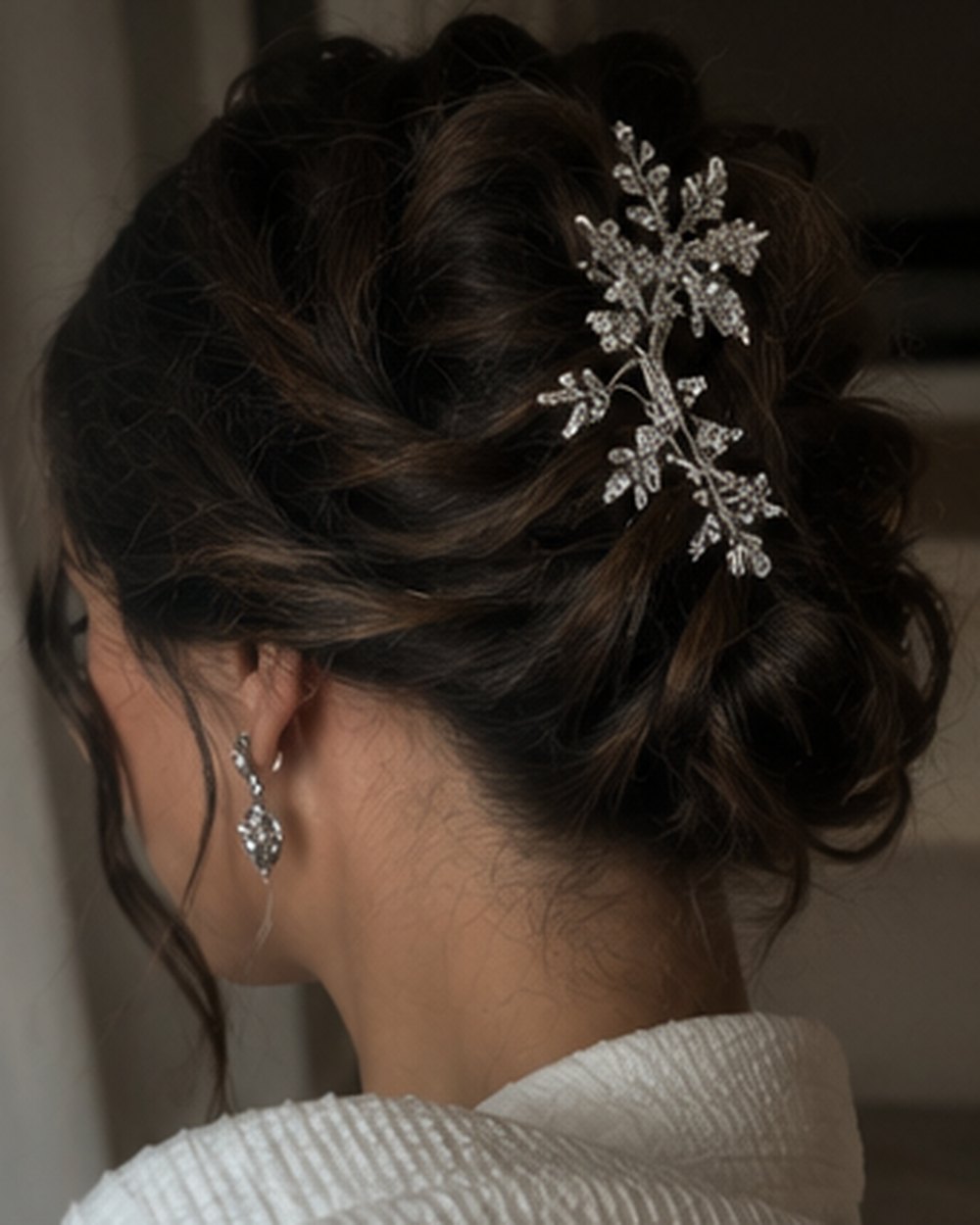 Dunkler Chignon mit Kristall-Haarschmuck und gelösten Konturen